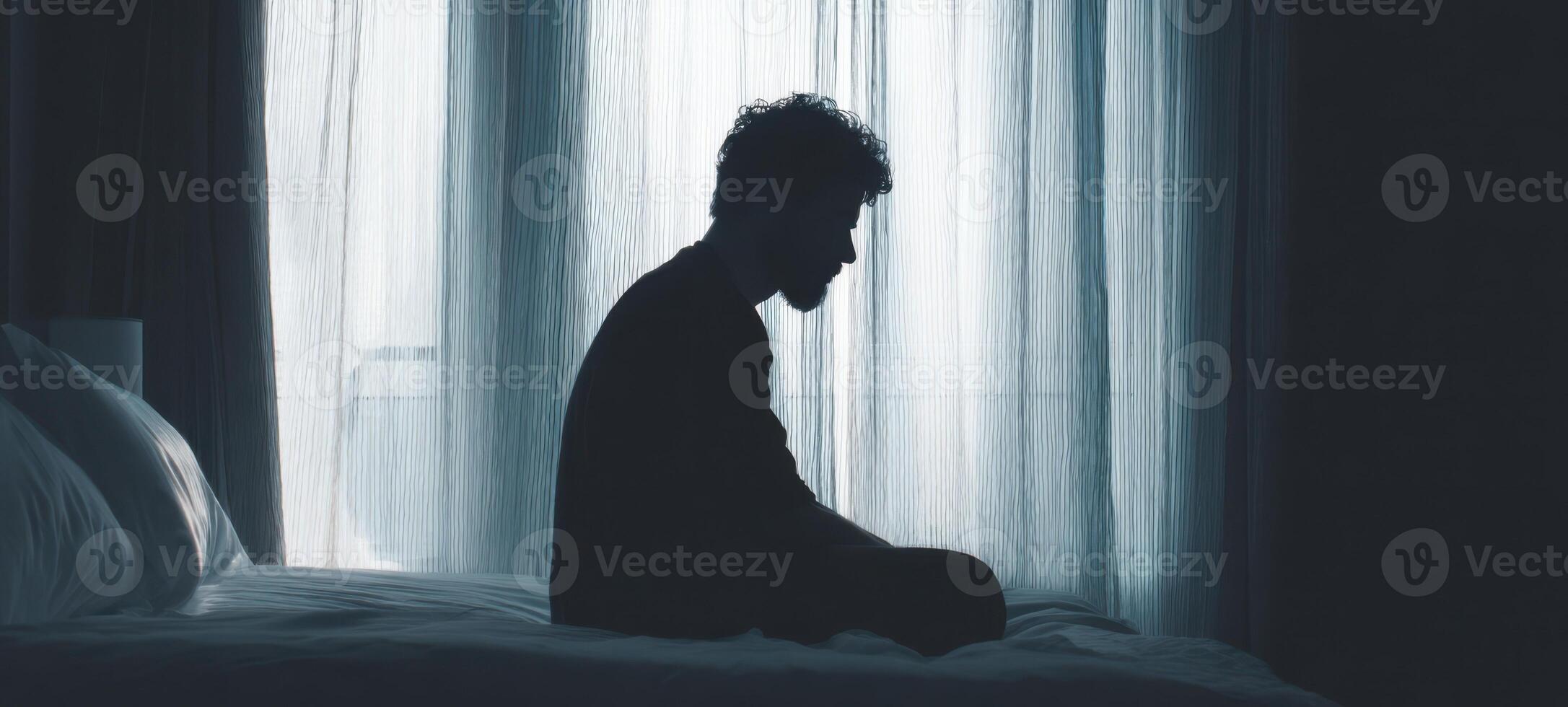 The silhouette of a man in deep contemplation at home. photo