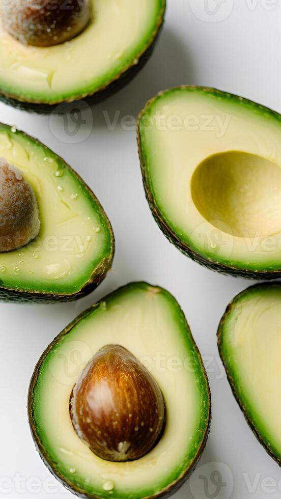 Sliced Avocados with Pits on White Surface photo