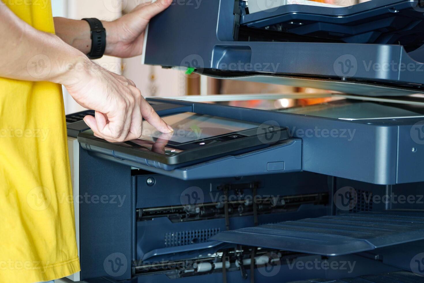 Men press the button of the copier. an copying paper from Photocopier. Men use printing machines. man using photocopier photo