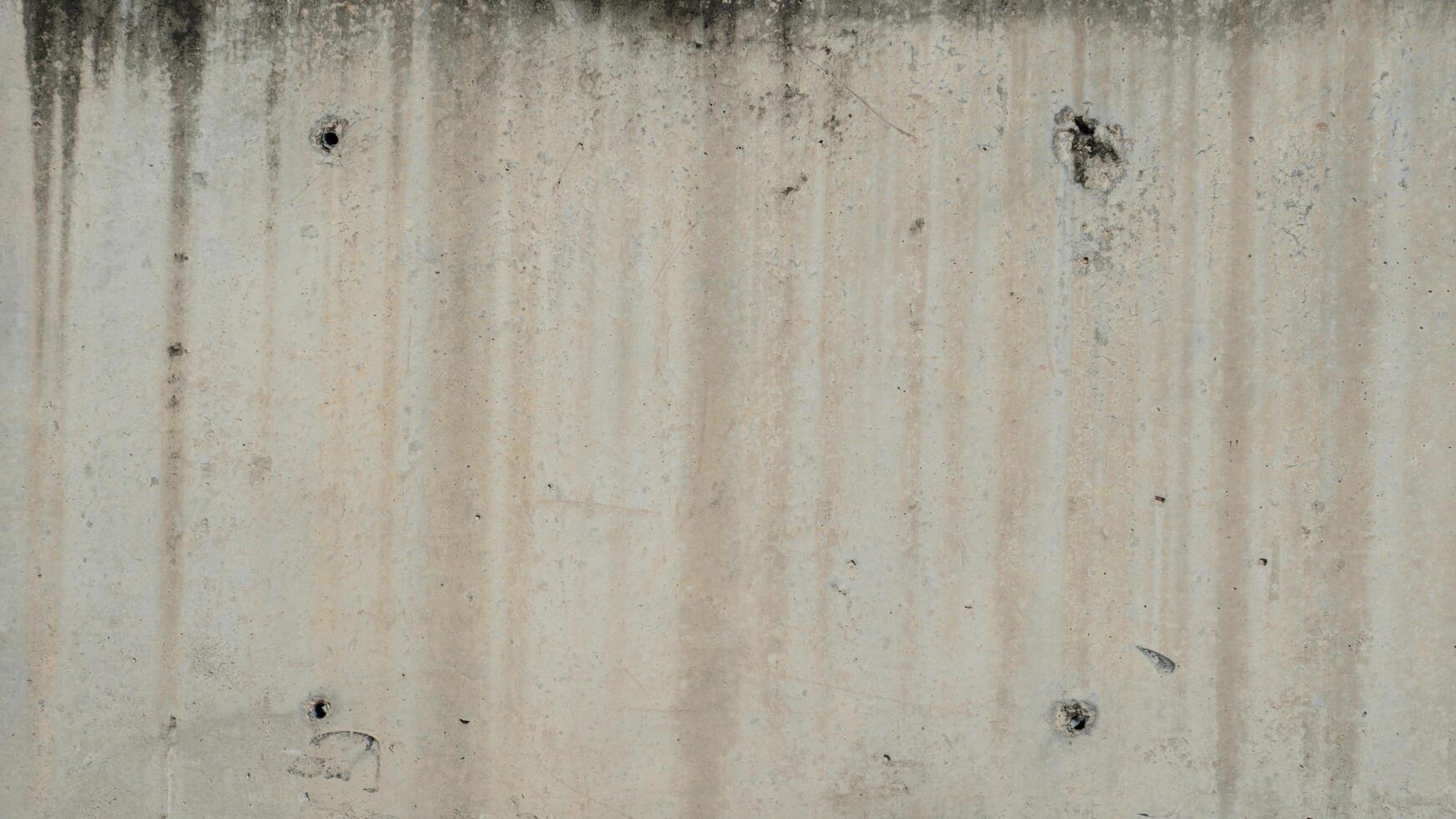 Cement wall with four surface drainage holes. Surfaces where water stains have accumulated and become black stains. For background and textured. photo