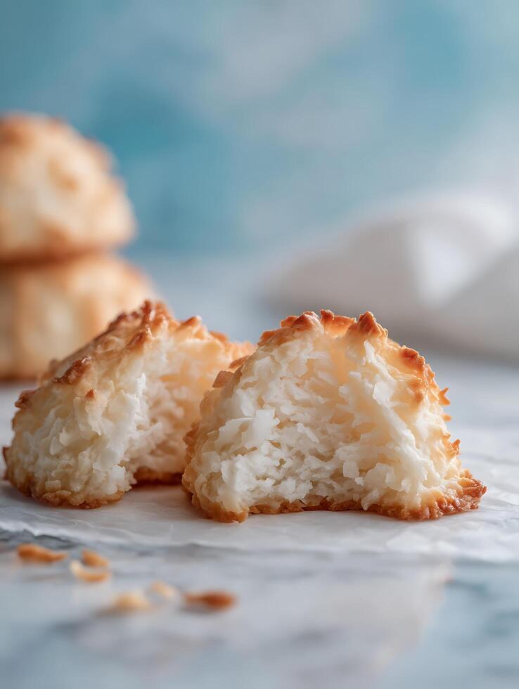 Close up of Two Broken Coconut Macaroons on White Paper. photo