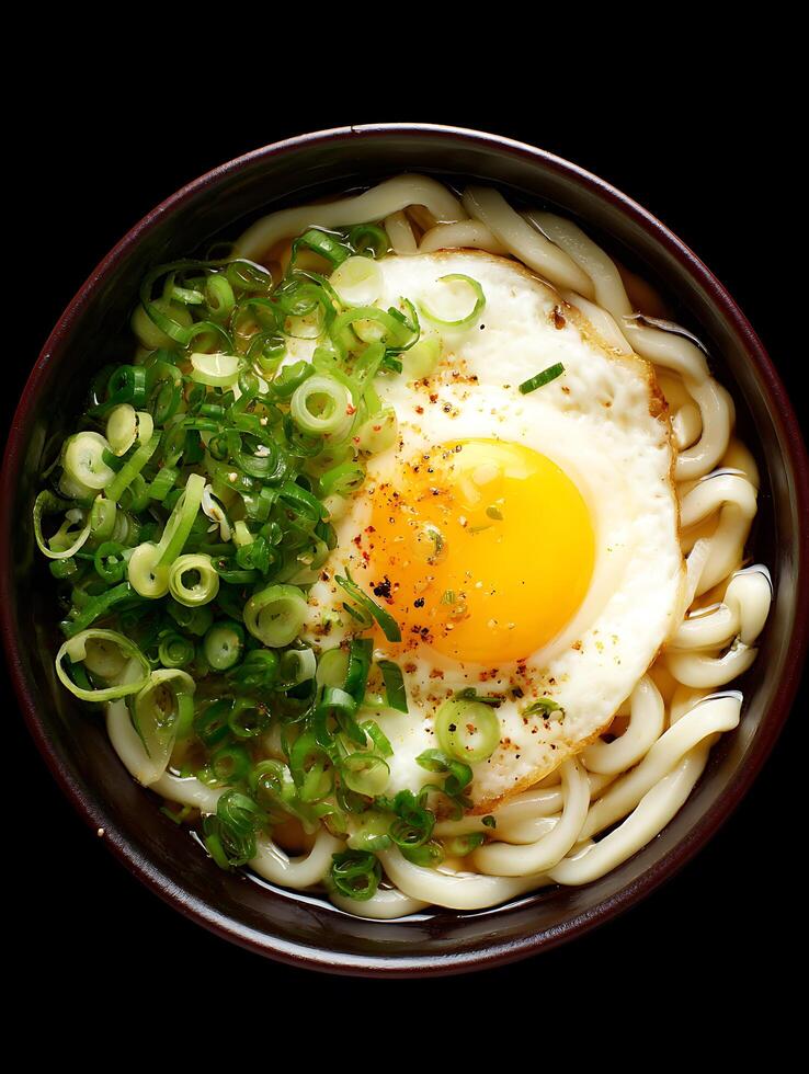 Delicious Udon Noodle Soup with Fried Egg and Green Onions. A close up overhead shot of a bowl of Japanese udon noodles. photo