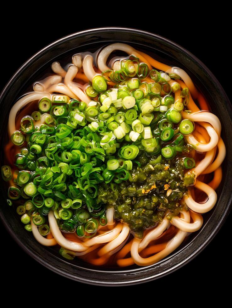 Delicious Udon Noodle Soup Close up of a bowl of udon noodles with green onions and a seaweed topping. photo