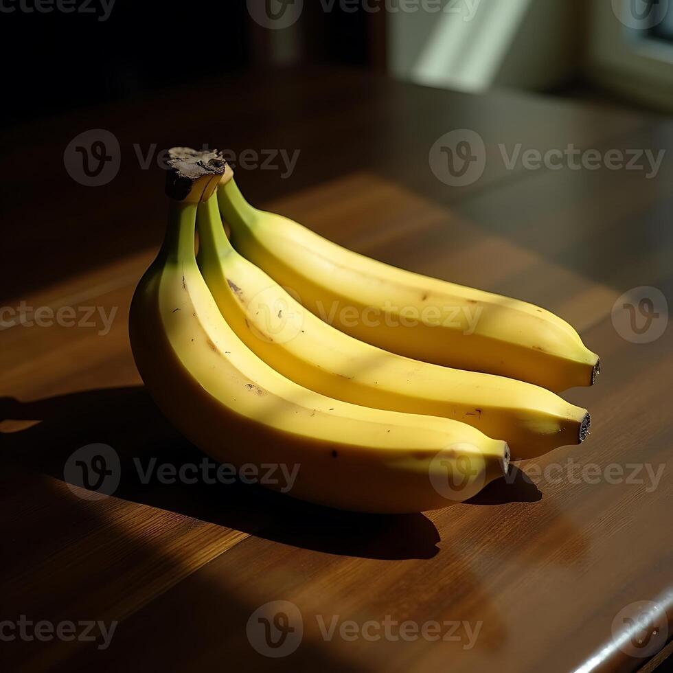 Bunch of Yellow Bananas on a Wooden Table Bathed in Sunlight photo