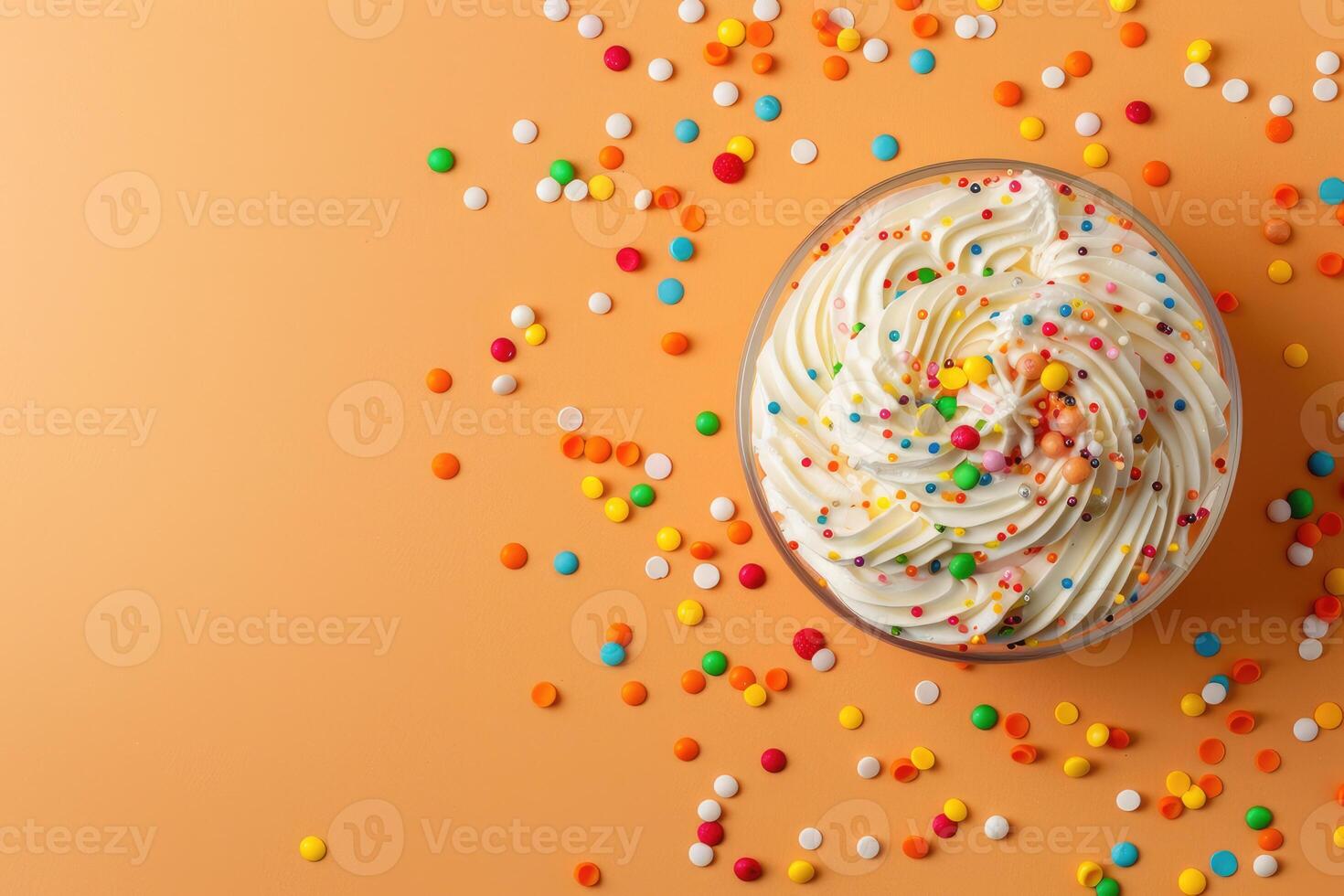 A bowl of whipped cream and colorful sprinkles on an orange background photo