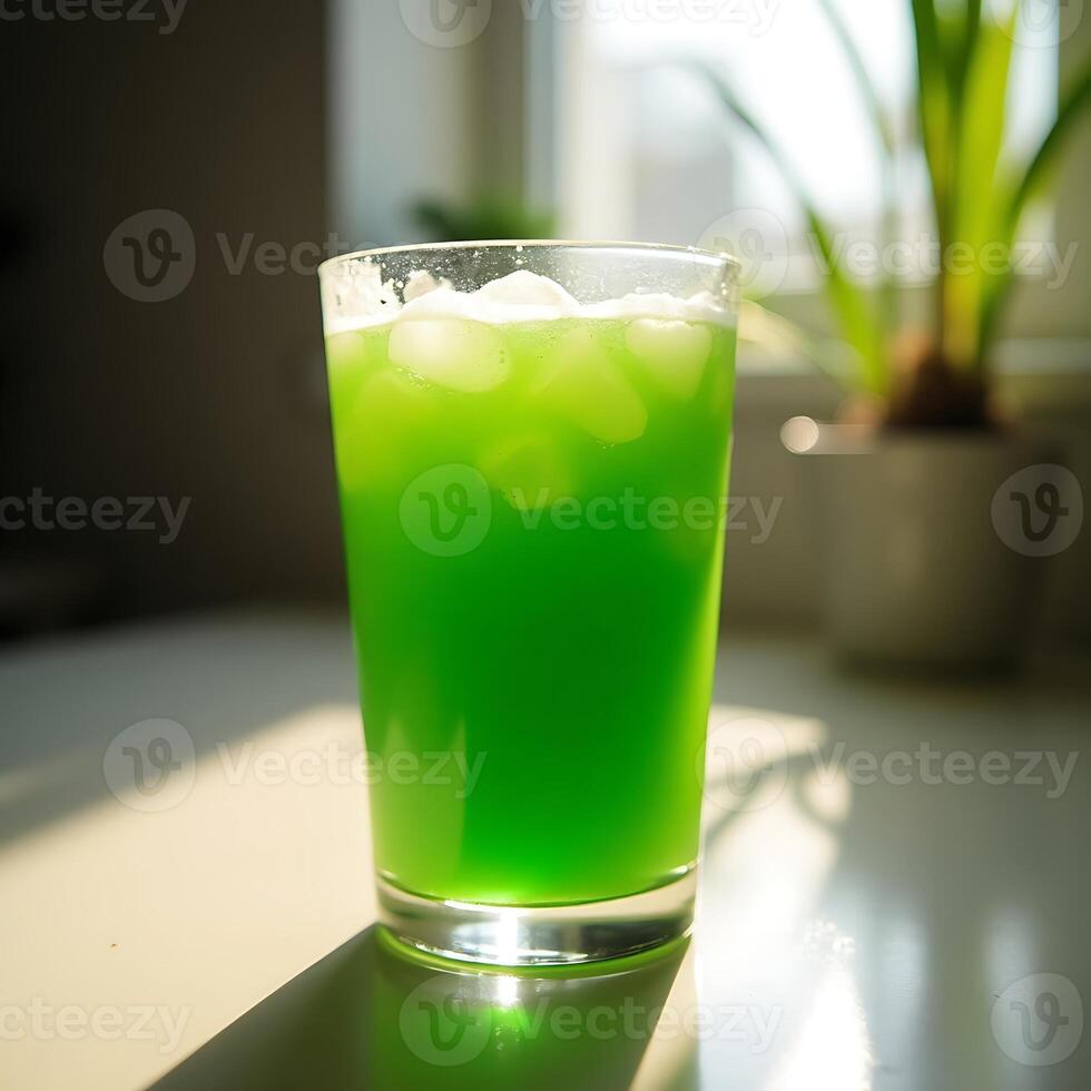Refreshing Green Drink with Ice Cubes on Sunny Counter photo