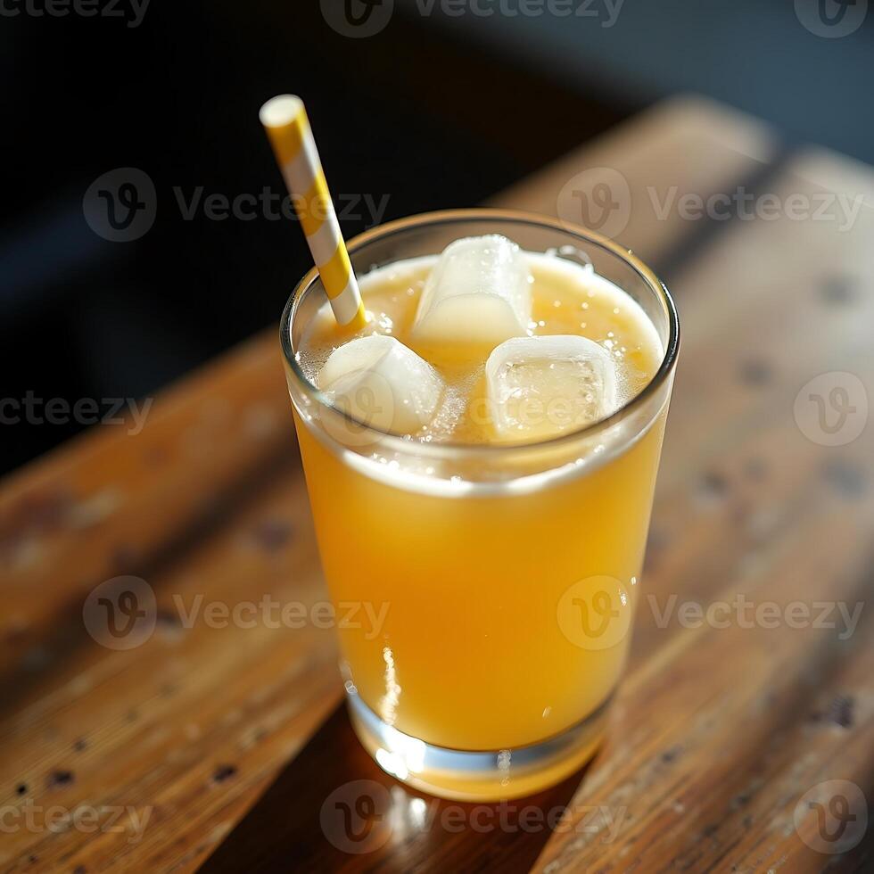 Drinking Orange Beverage with Ice and Straw on Wooden Surface photo