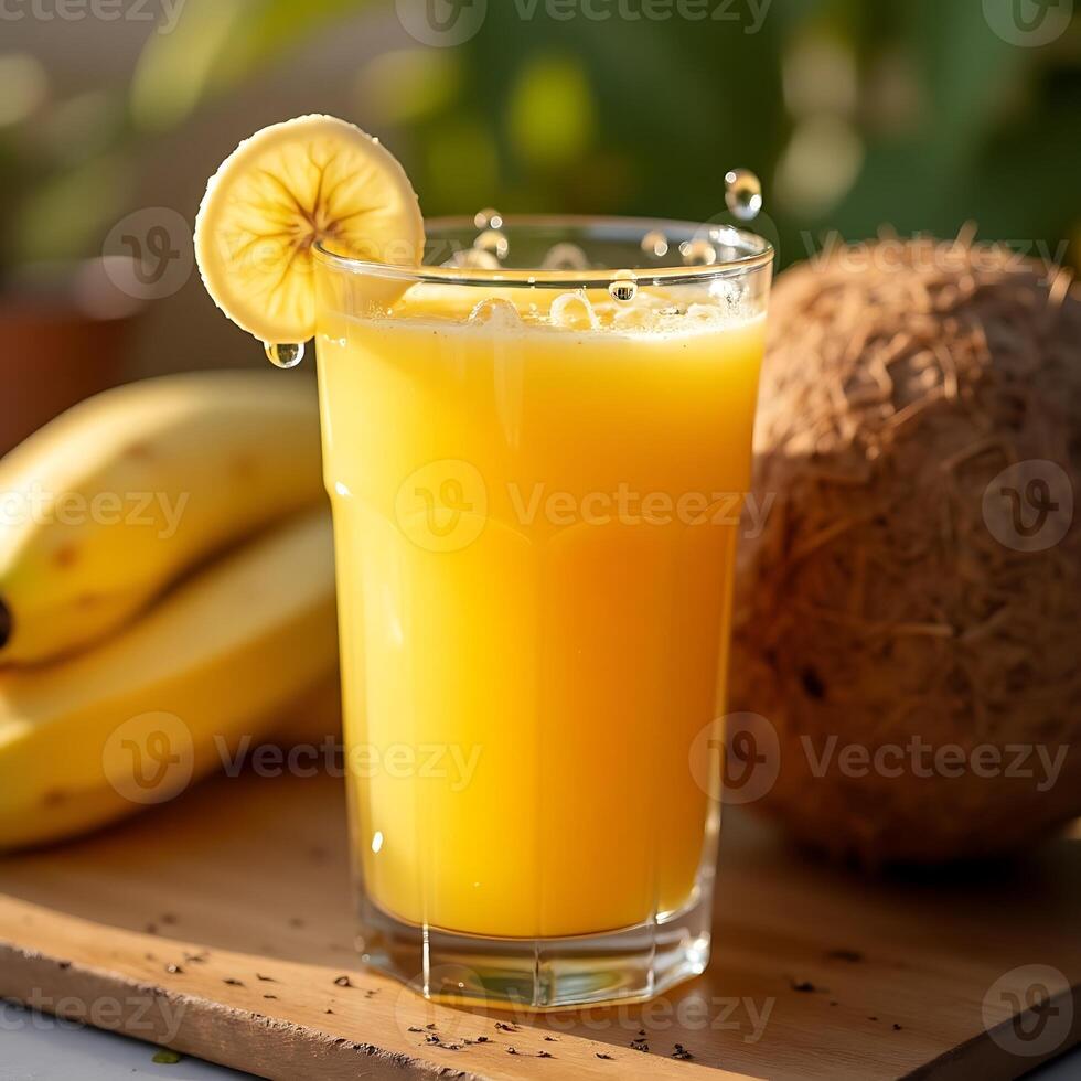 Pouring Fresh Tropical Juice in Glass with Banana and Coconut photo