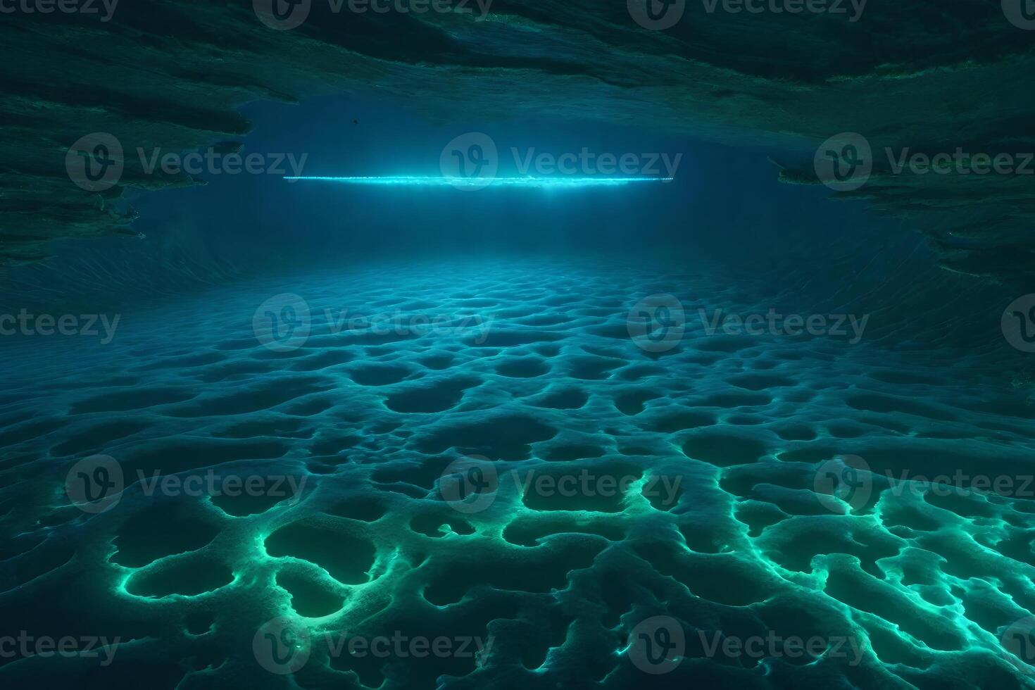 An underwater cave with glowing light coming from the bottom photo