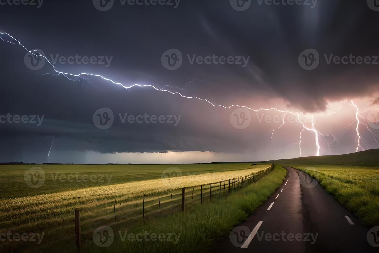 Lightning strikes over a road in the middle of a field photo