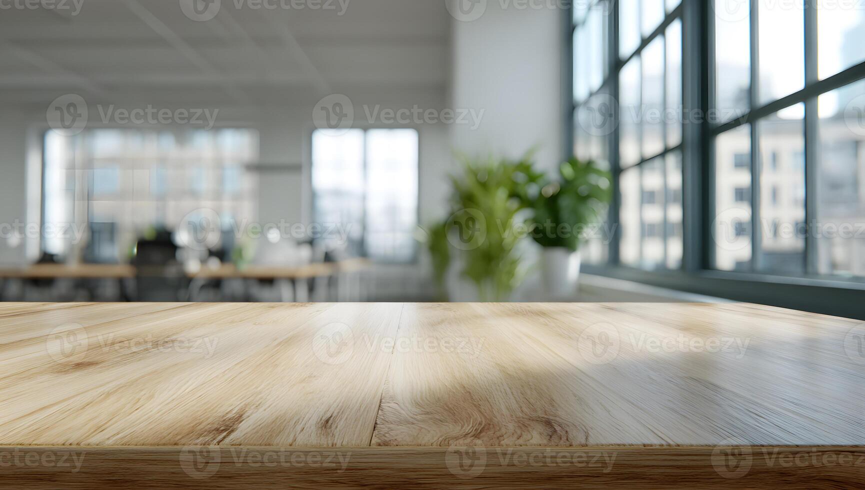 Light brown wooden table surface in front of a blurred office space with large windows. photo