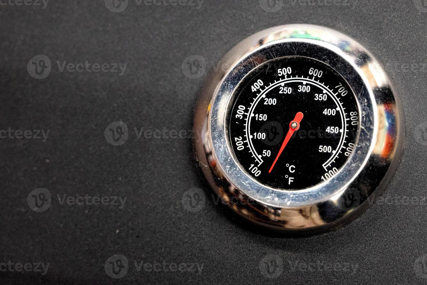 Close-up of thermometer with red needle on black surface. photo