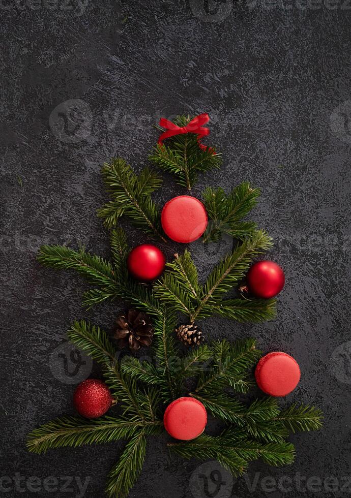 . A wintry flat lay with a coffee cup, gingerbread trees, cinnamon, candy canes, and pine sprigs, creating a visually appealing Christmas scene on a dark surface. photo
