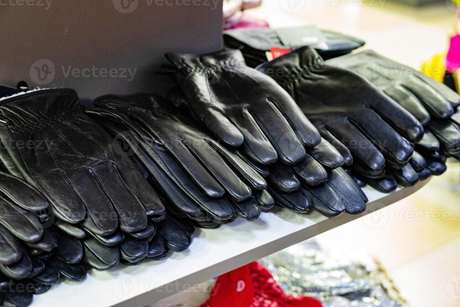 Multiple pairs of black leather gloves on a store shelf. photo