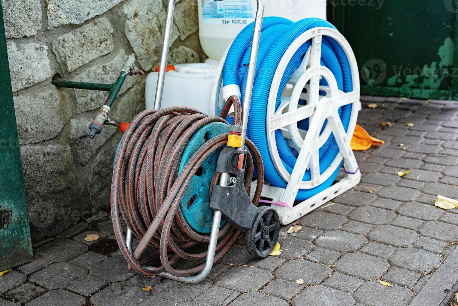 Garden hose reels on a stone wall background. photo