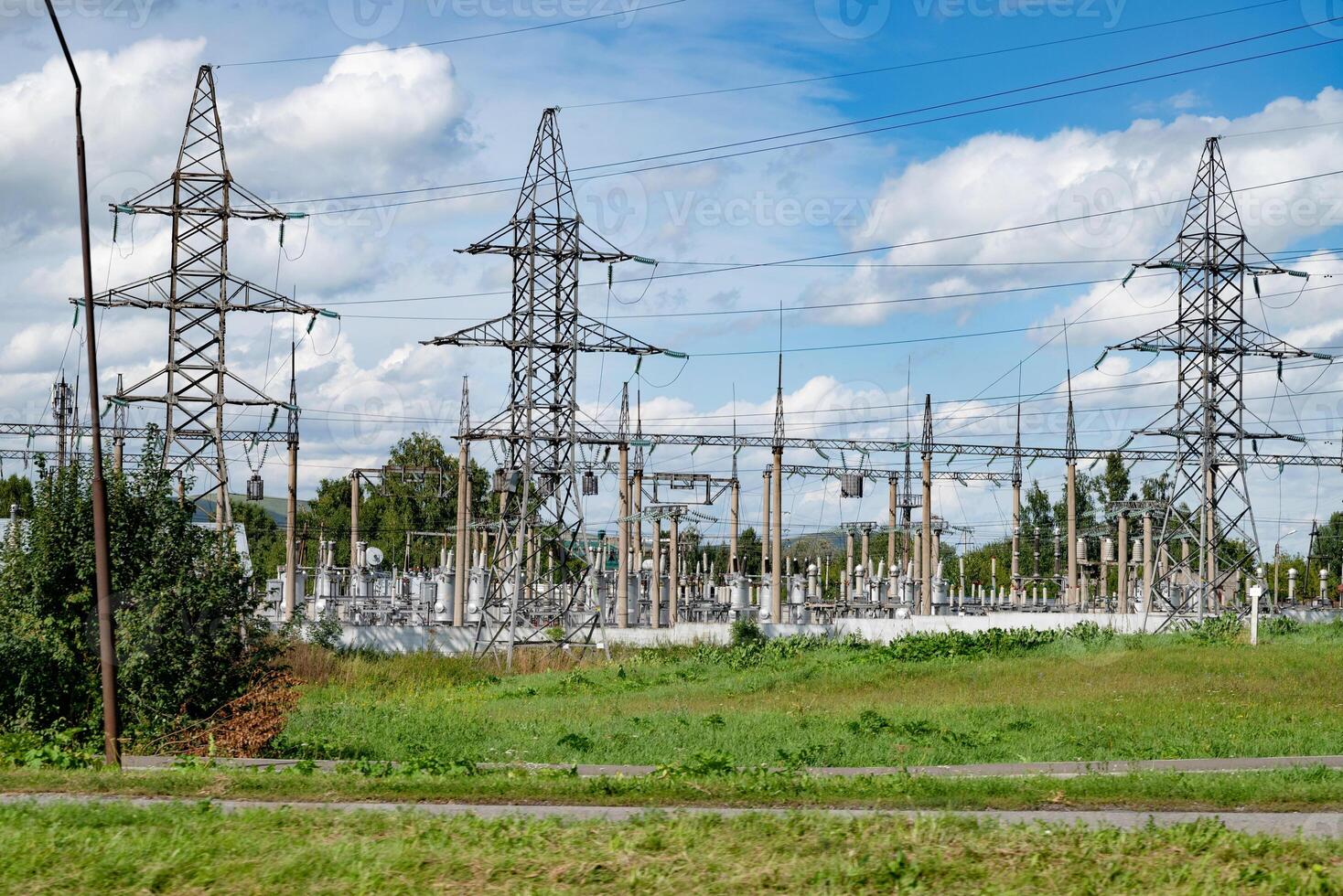 Power substation with high-voltage towers and cables in a rural area.. photo
