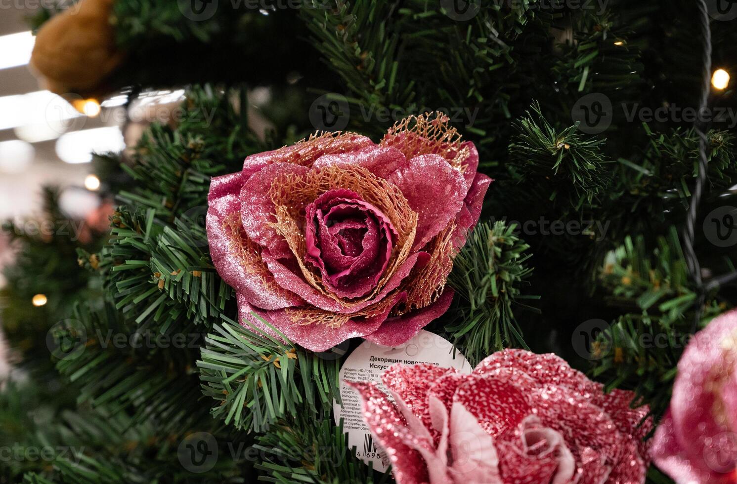 The image captures a Christmas tree with various ornaments in pink and burgundy tones, highlighted by a butterfly decoration. photo