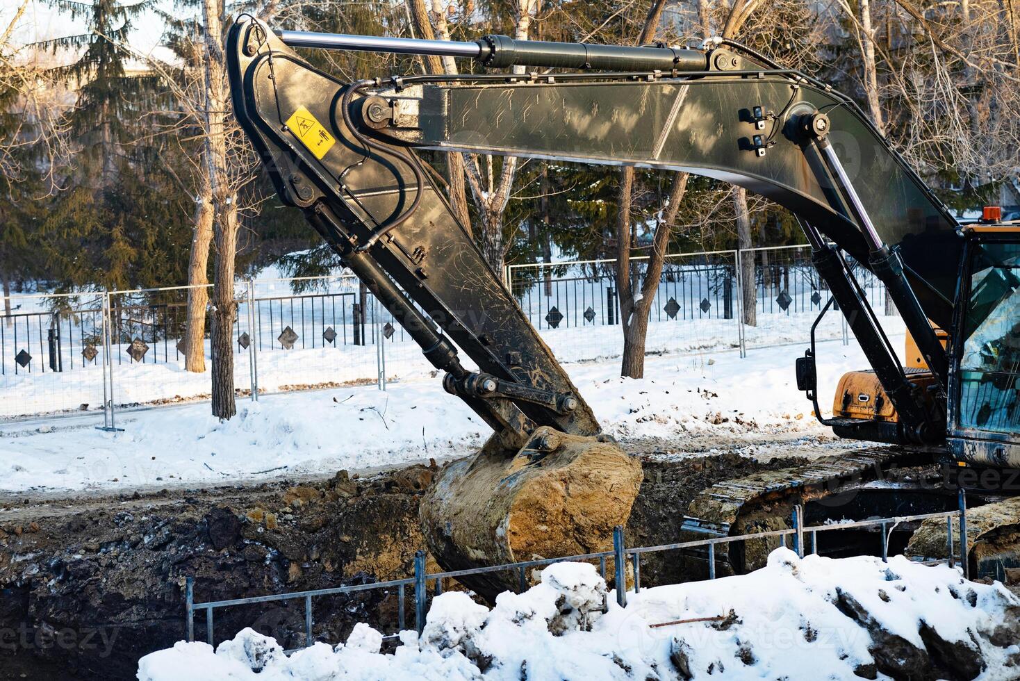 Excavator during earthmoving at open pit on blue sky background. Construction machinery and earth-moving heavy equipment for excavation photo