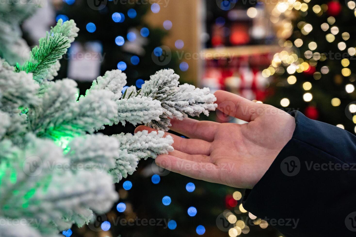 A window ledge decorated for the holidays with a garland, red ornaments, and miniature string lights is shown. photo