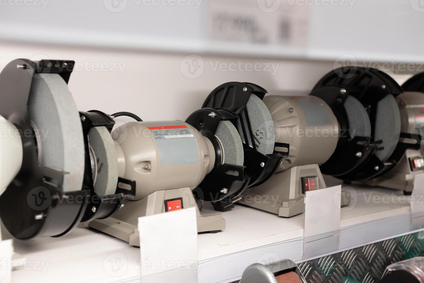 Various grinding machines displayed on a shelf in a tool store during daylight hours photo