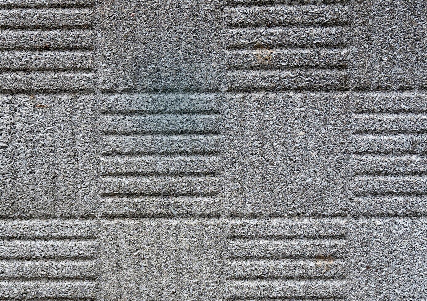 Close-up of patterned concrete texture with grooves and rough surface. photo