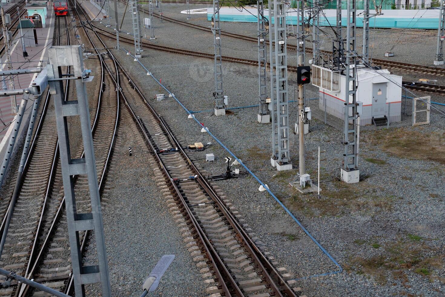 Railway tracks and signal lights near a transit station during the early morning hours photo