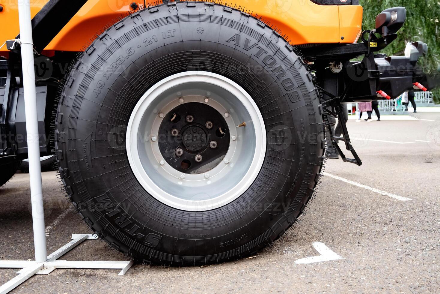 tractor wheel with orange rim on grassy ground. photo