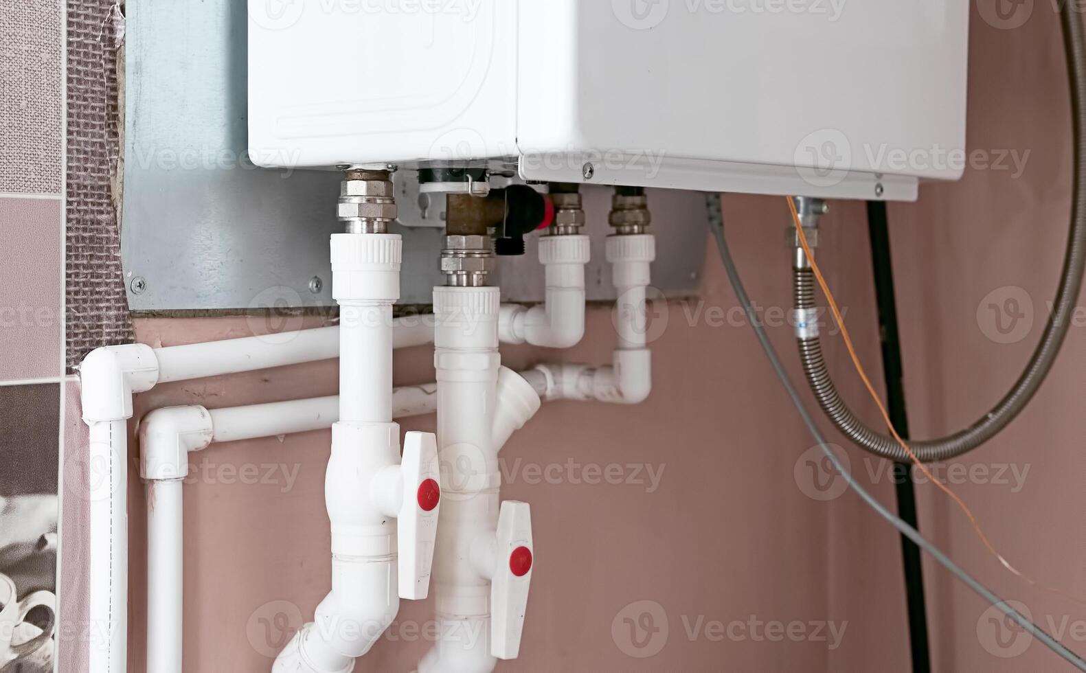 Plumbing system showcasing a modern water heater and connected piping in a residential utility area photo