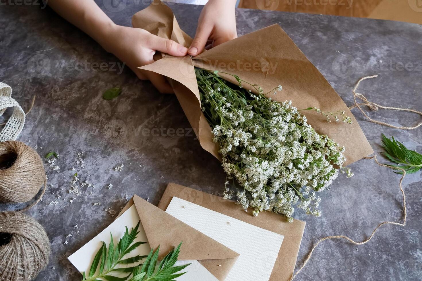 he arrangement of the items envelopes, flowers, gift box, and scissors suggests a thoughtful and creative workspace, possibly for preparing handmade gifts or personalized letters. photo