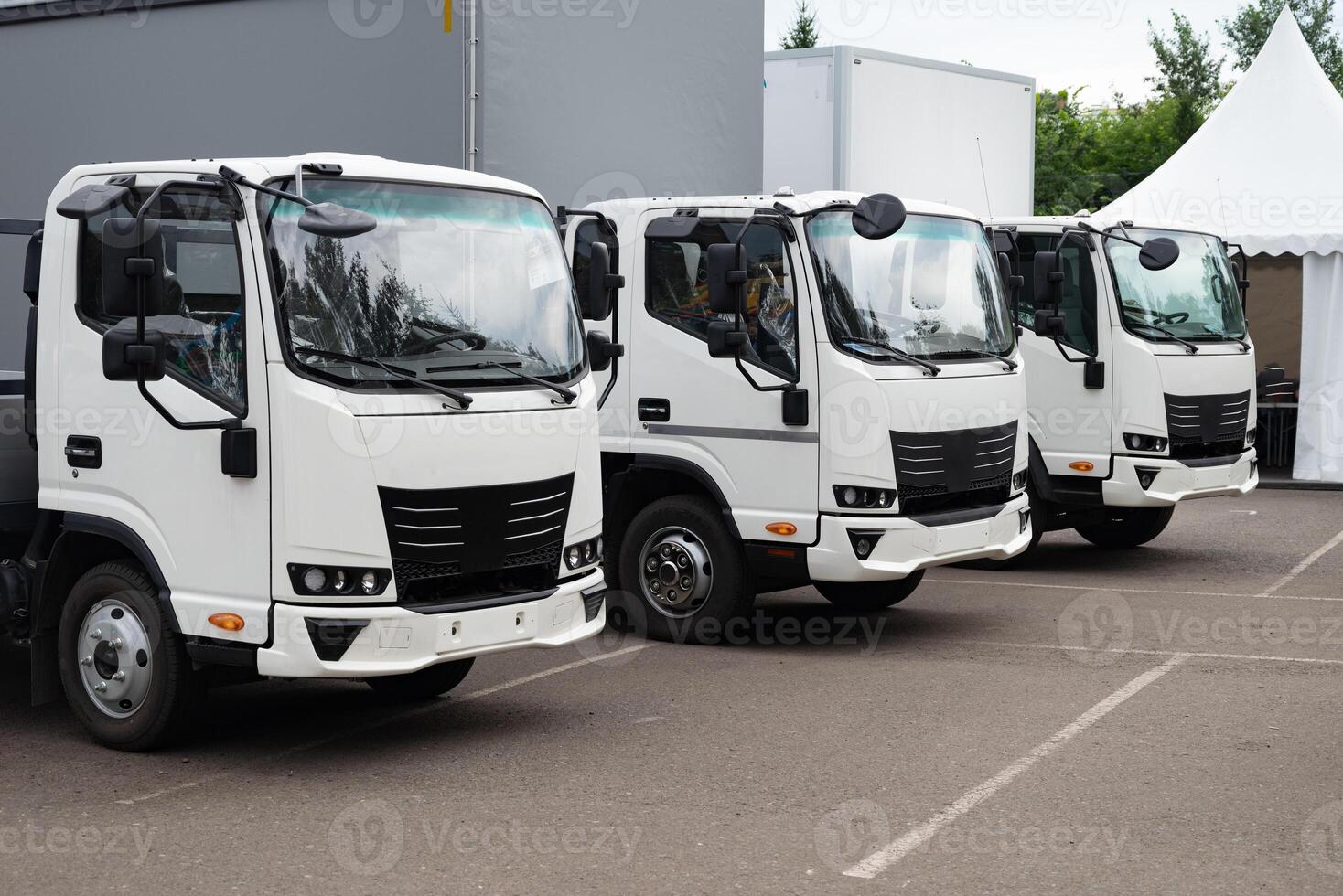 Fleet of white delivery trucks parked in a lot. photo