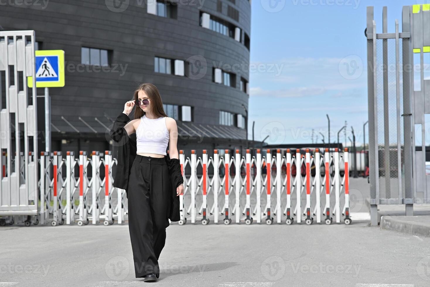 She has one hand resting on her head, creating a relaxed and confident pose. photo