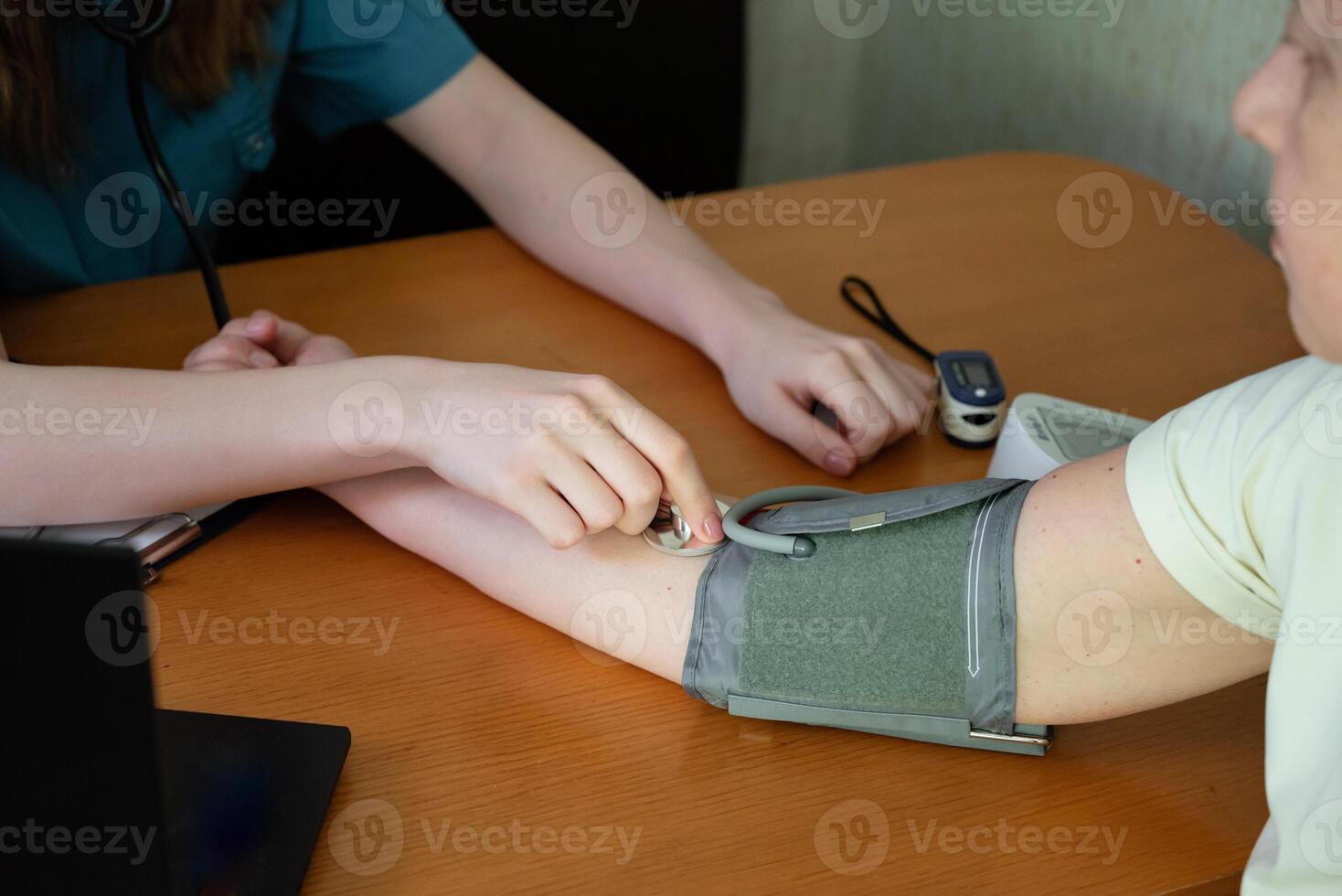 Medical professional taking notes while examining a patient in a clinical setting photo