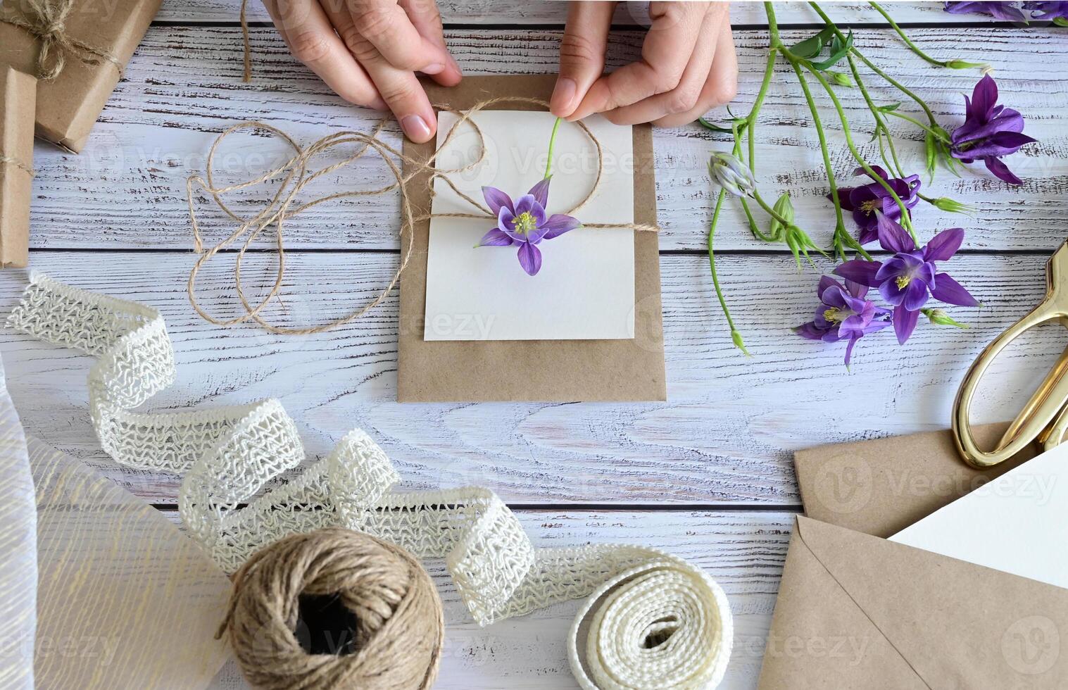 In the upper right corner, a small gift box wrapped in brown paper and tied with a simple string sits neatly, complementing the natural and minimalistic aesthetic of the overall composition. photo