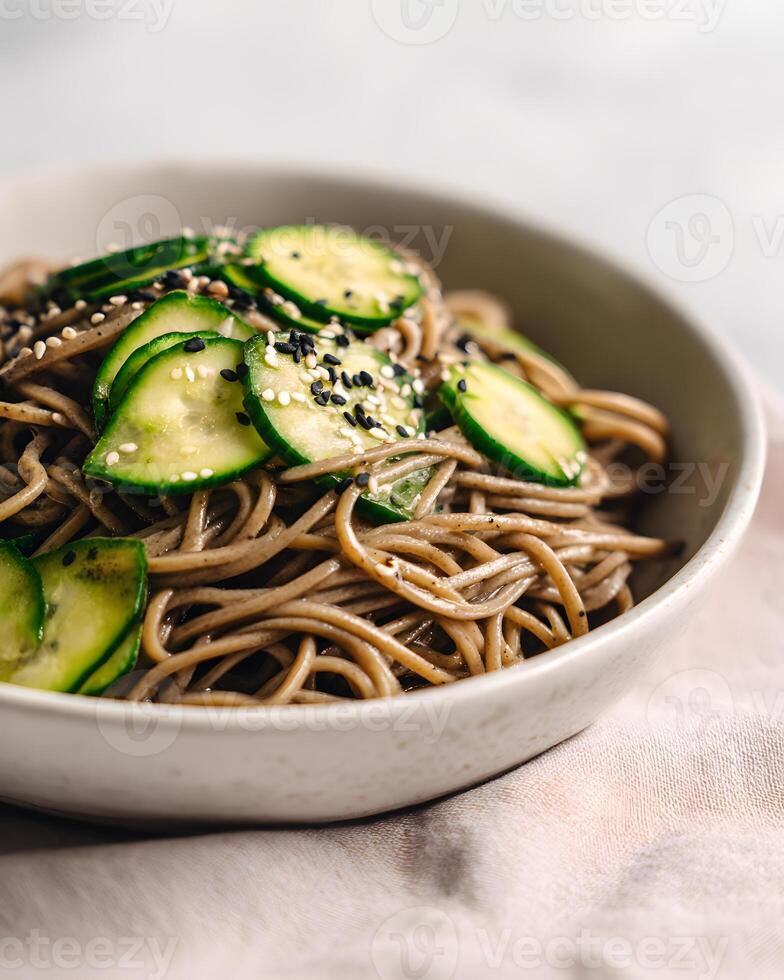Fresh Japanese soba noodle salad with crunchy cucumber and sprinkled black and white sesame seeds photo