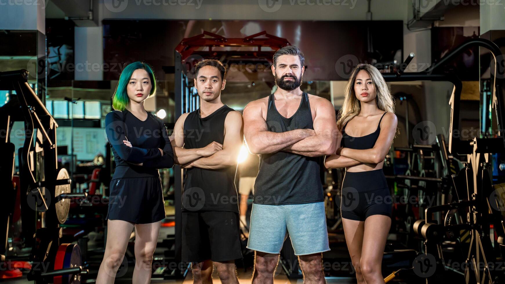 Confident multicultural fitness team standing strong together in modern gym, symbolizing teamwork, empowerment, diversity, and commitment to healthy lifestyle goals. photo