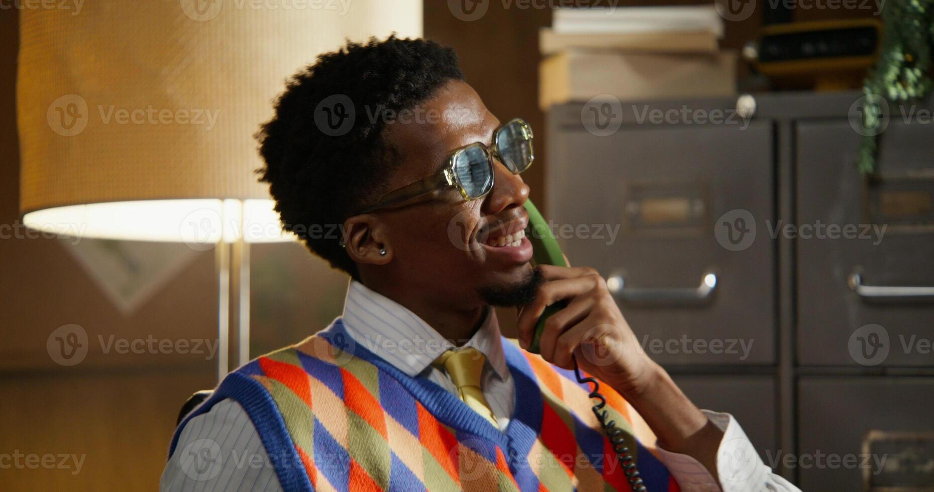 A man is talking on a wired phone. Animated facial expressions on his face. The is getting closer to the face photo