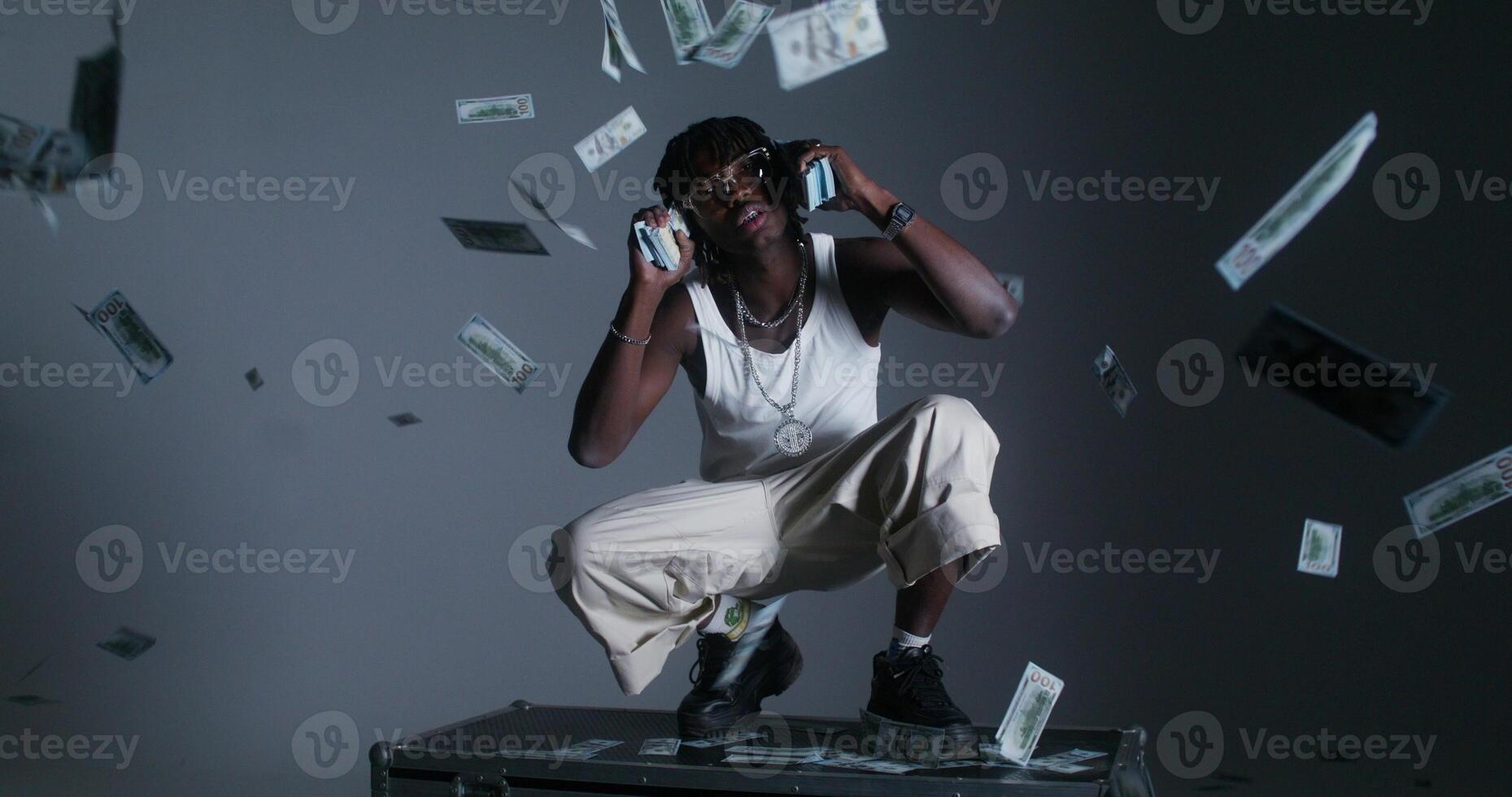 A photo shoot of a stylish modern man with dollar bills. He looks at the camera with serious look