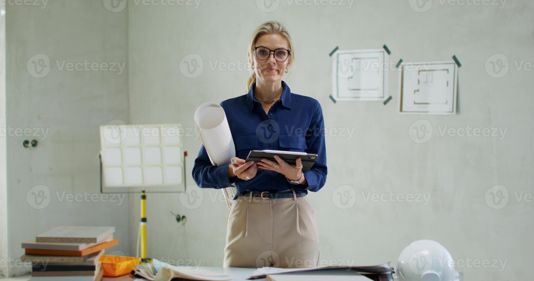 Portrait of a designer at a construction site. A woman holds a tablet in her hands photo