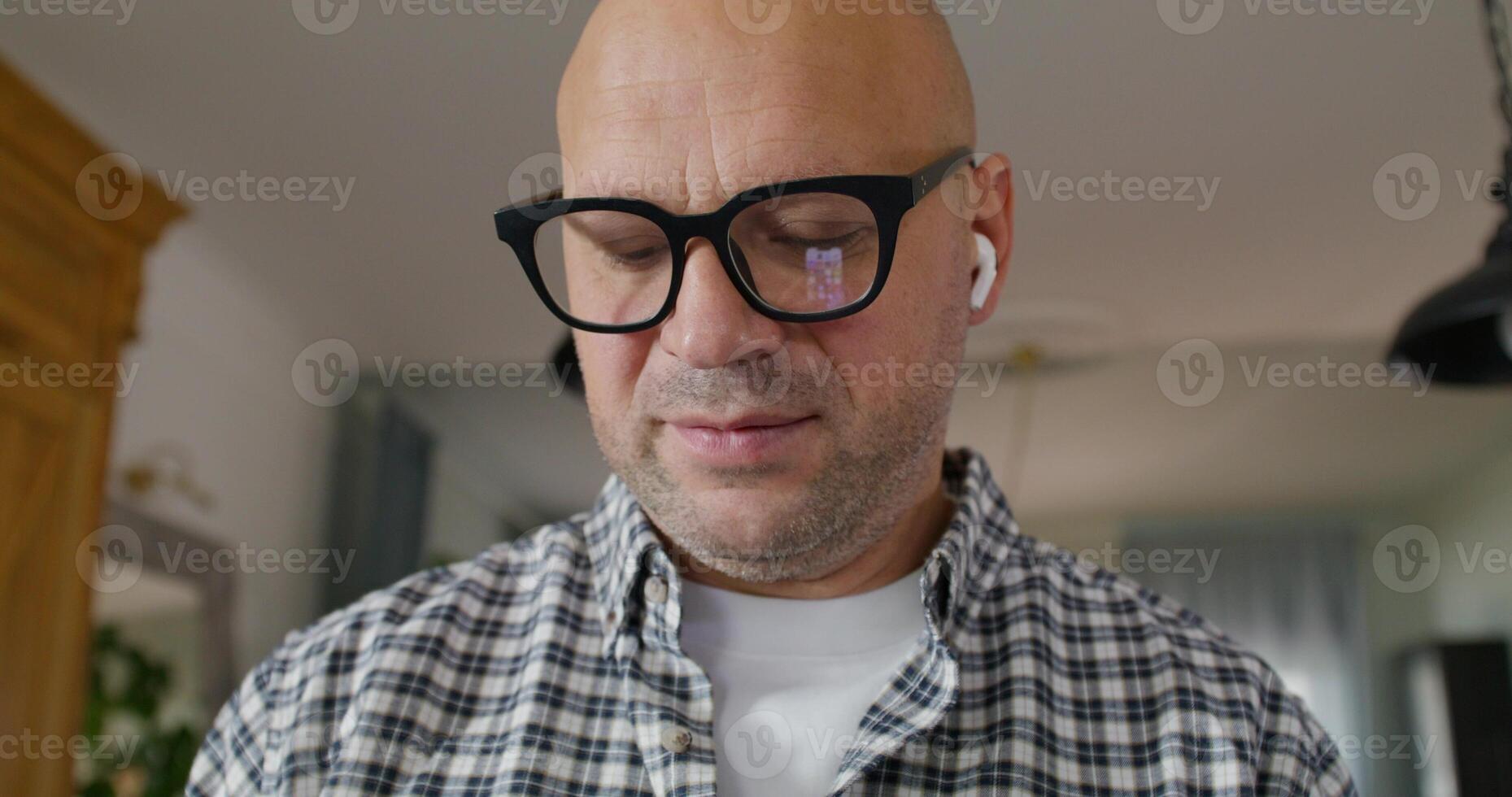 Portrait of a man when he talks on earphone. He's smiling at the camera, close-up of his face photo
