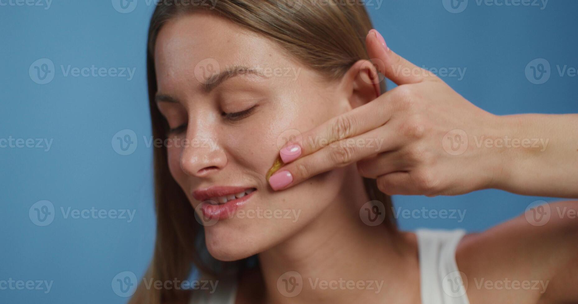 A woman putting a piece of skin on her face photo