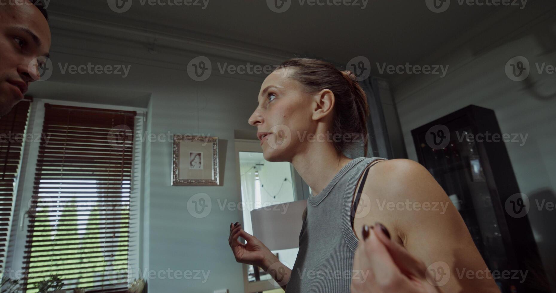 Husband and wife yell at each other and jostle while standing at home. A family quarrel photo