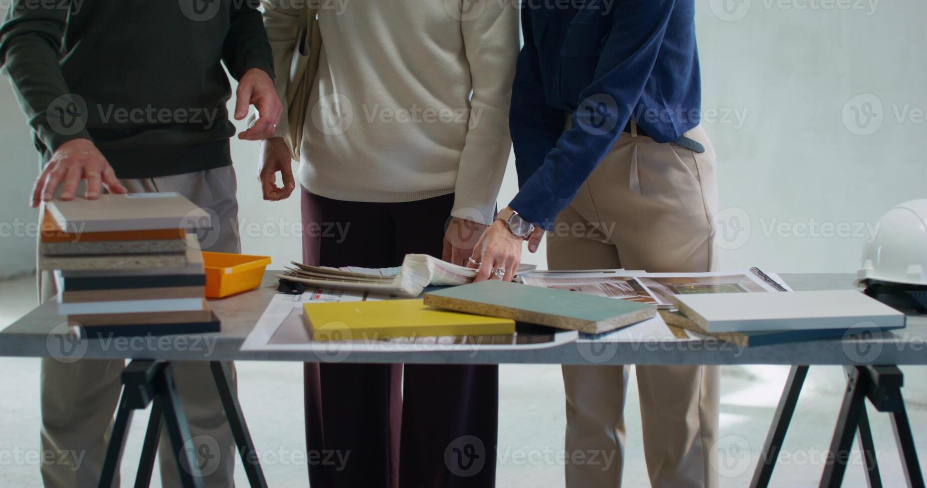 The realtor talks to the customers and shows them the project of the house. Work on a construction site photo