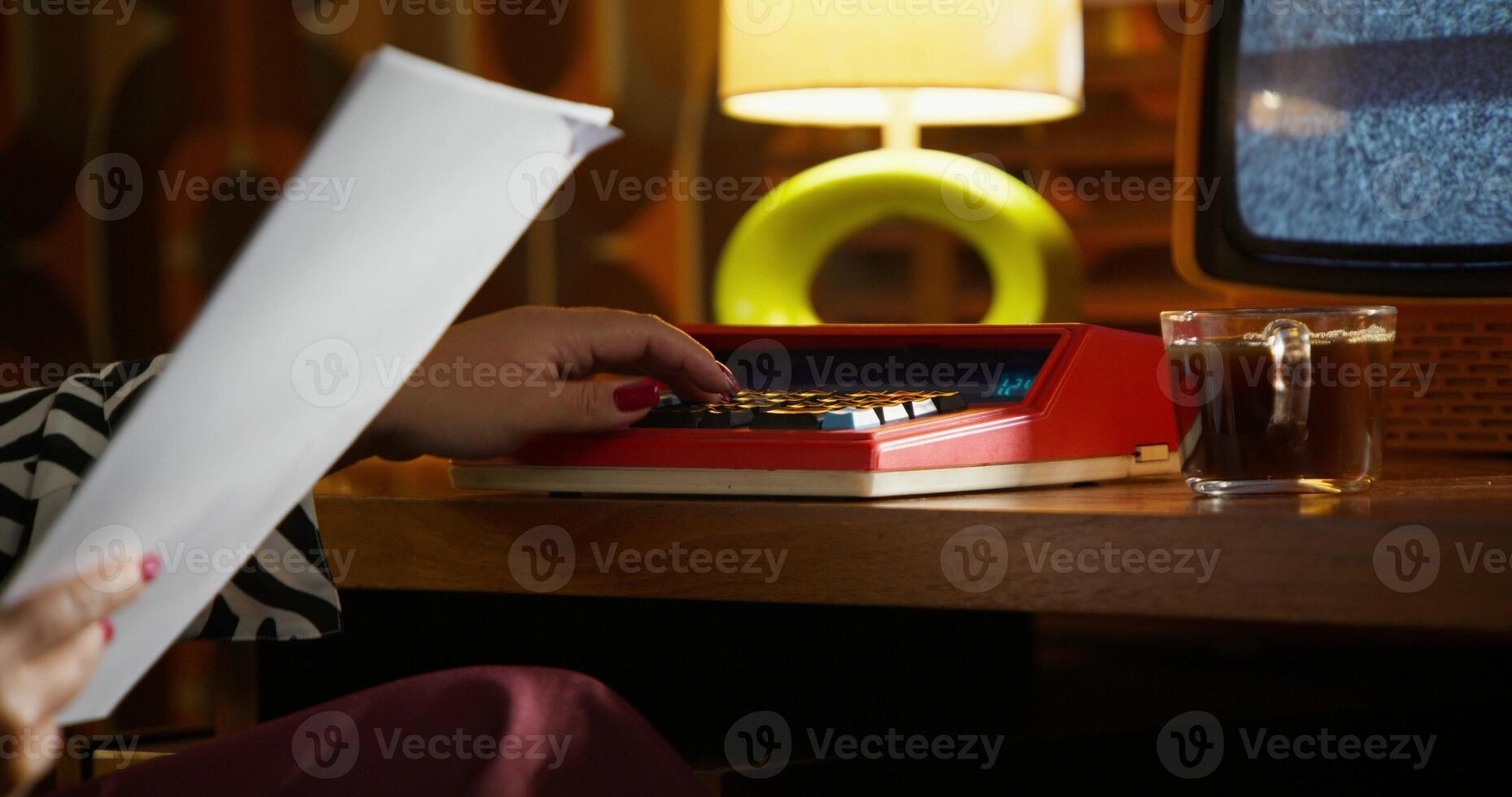 Women count on an old massive calculator. Accountant's job in a retro office. photo