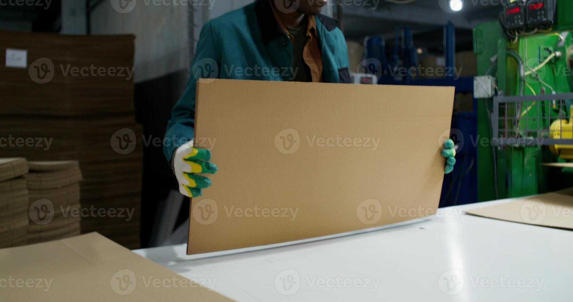 A paper mill worker puts sliced cardboard in stacks. The box production process photo