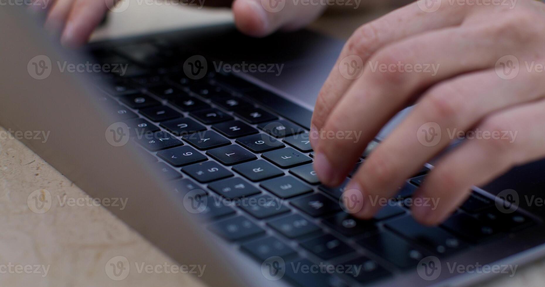 Close-up of a man's hands and keyboard as he taps on a laptop. photo