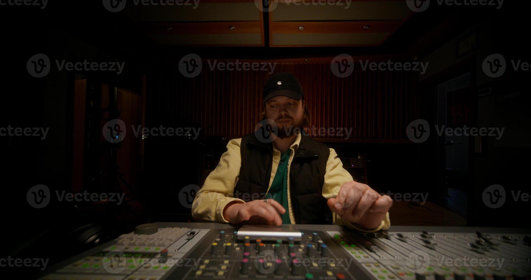 The work in a music recording studio. A man dances while controlling an audio mixer photo