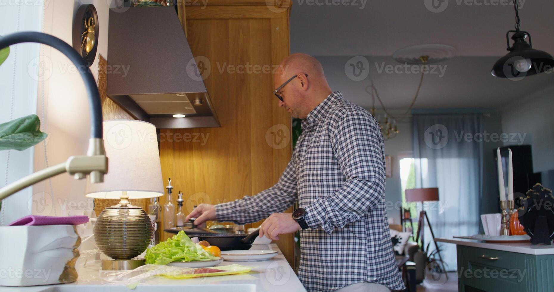 A man Cooks breakfast at home. He pours oil into the pan and starts frying photo