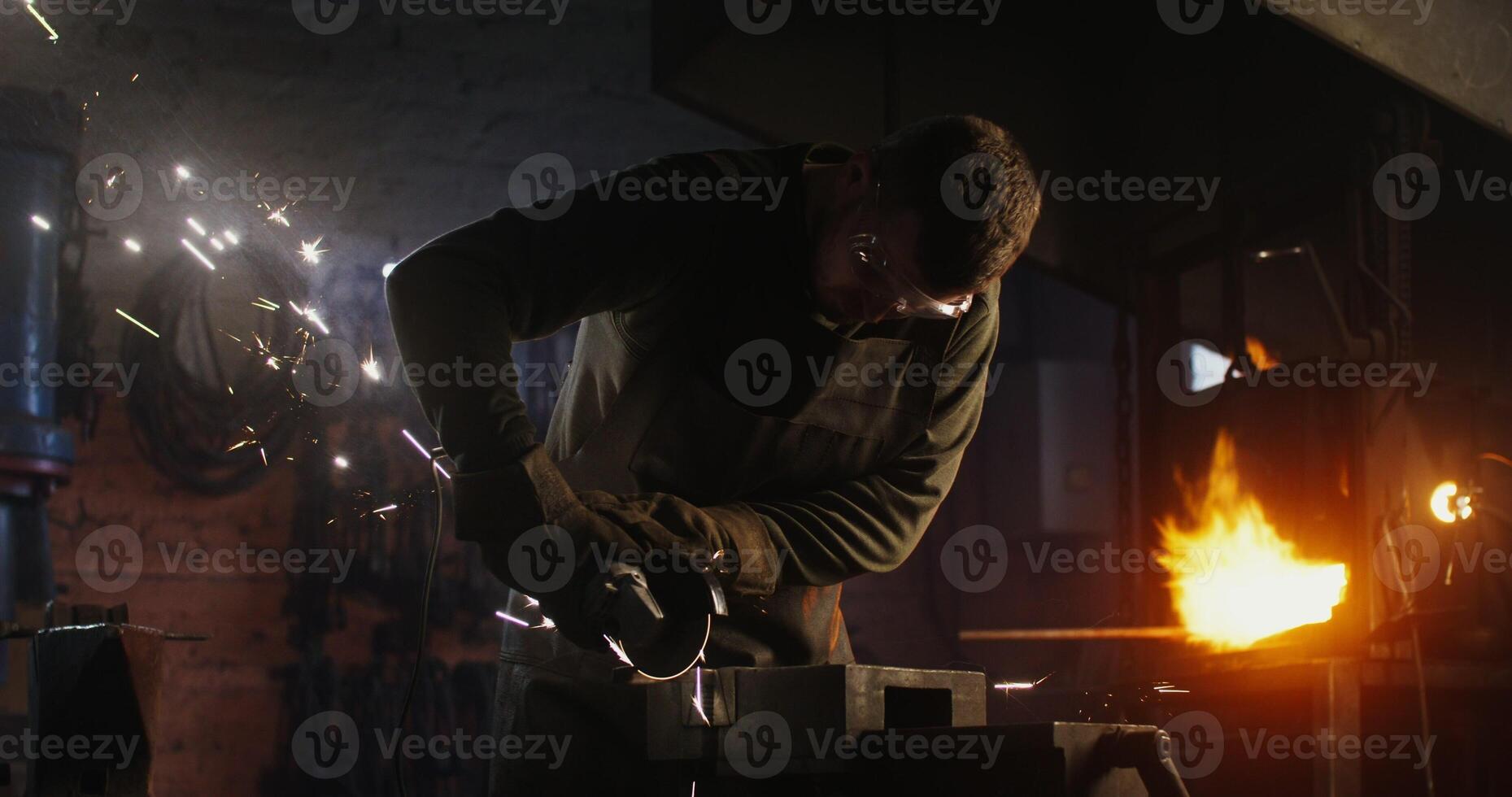 A man is working on a piece of metal with sparks photo