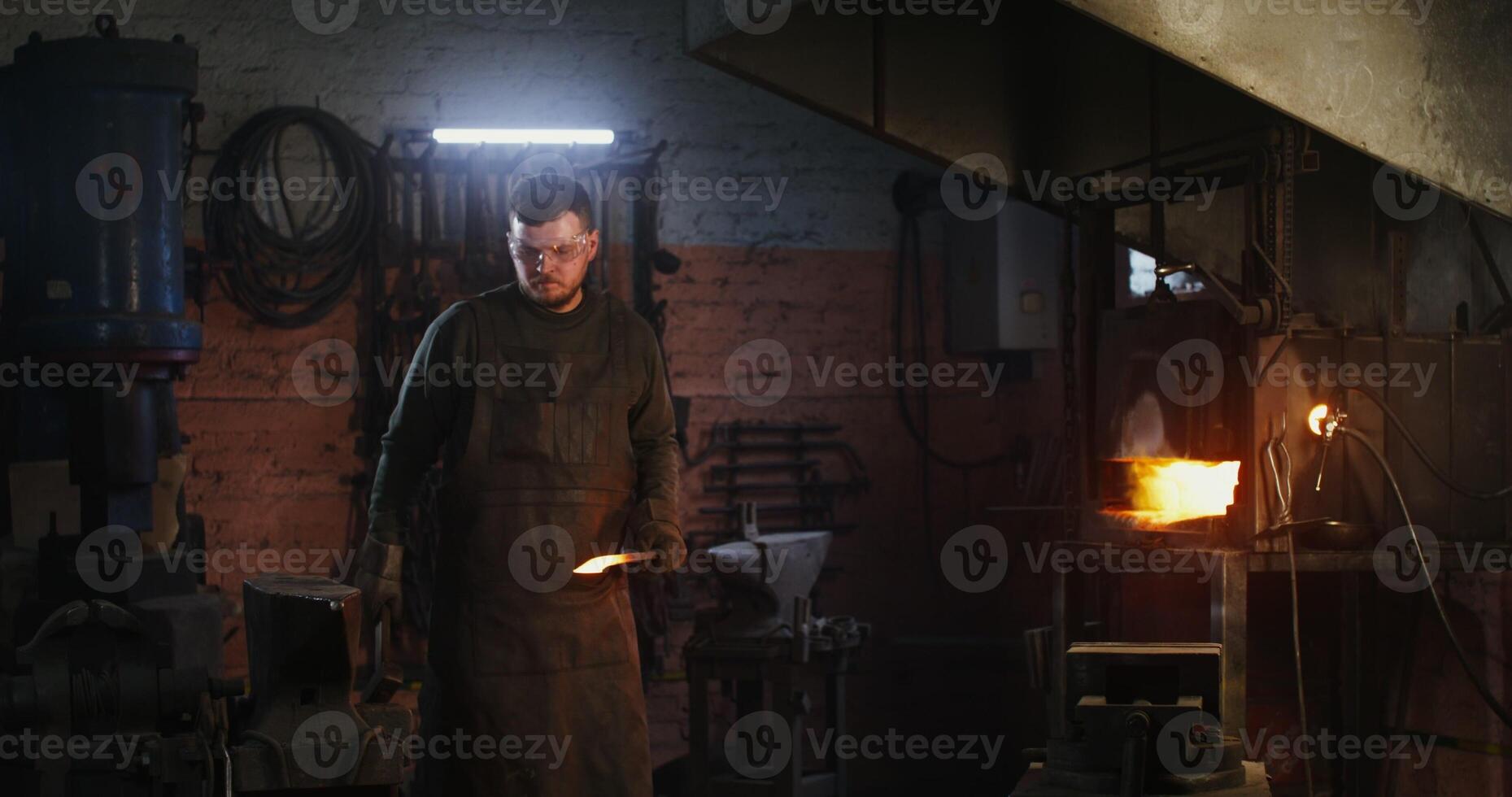 A man is standing in front of a furnace photo
