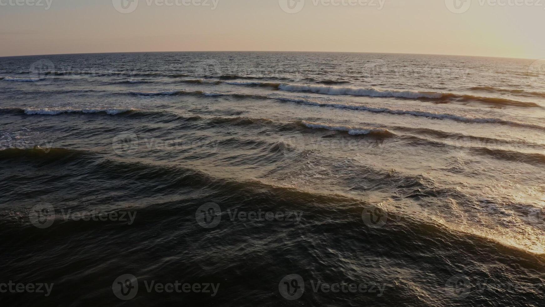 Panoramic view of the sea distance during dawn. Large foamy waves in the sun, from a drone. photo